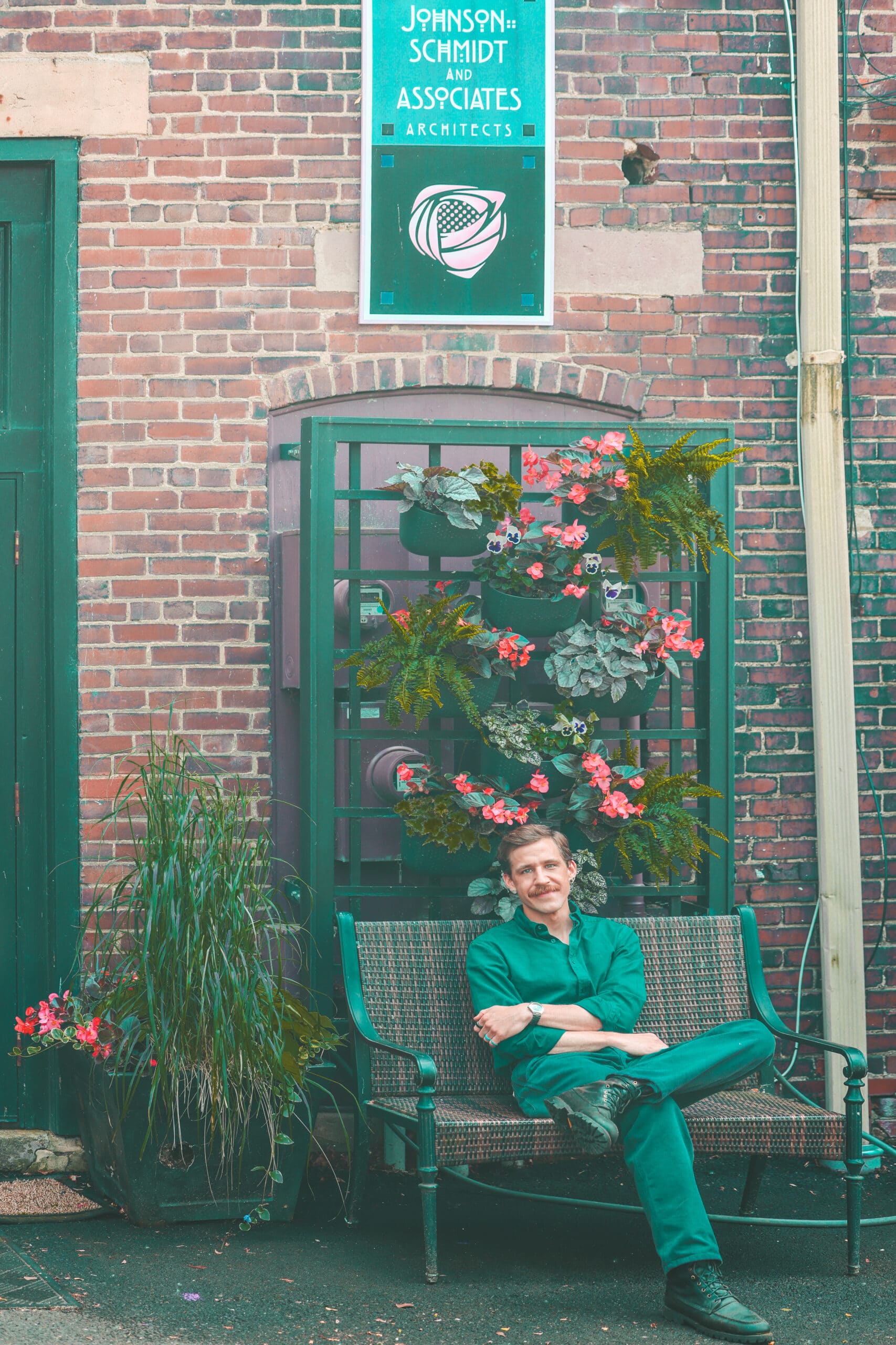 Man in a green jumpsuit sitting on a vintage motorcycle in the park
