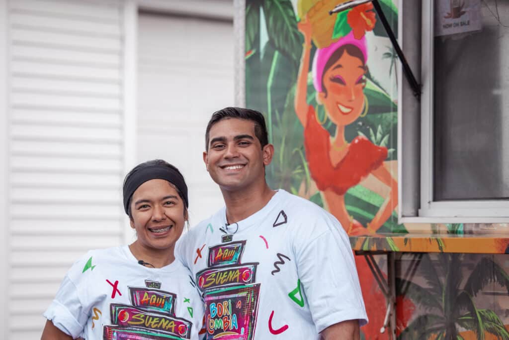 Clara and Benny Boricombia standing together outside their colorful food truck