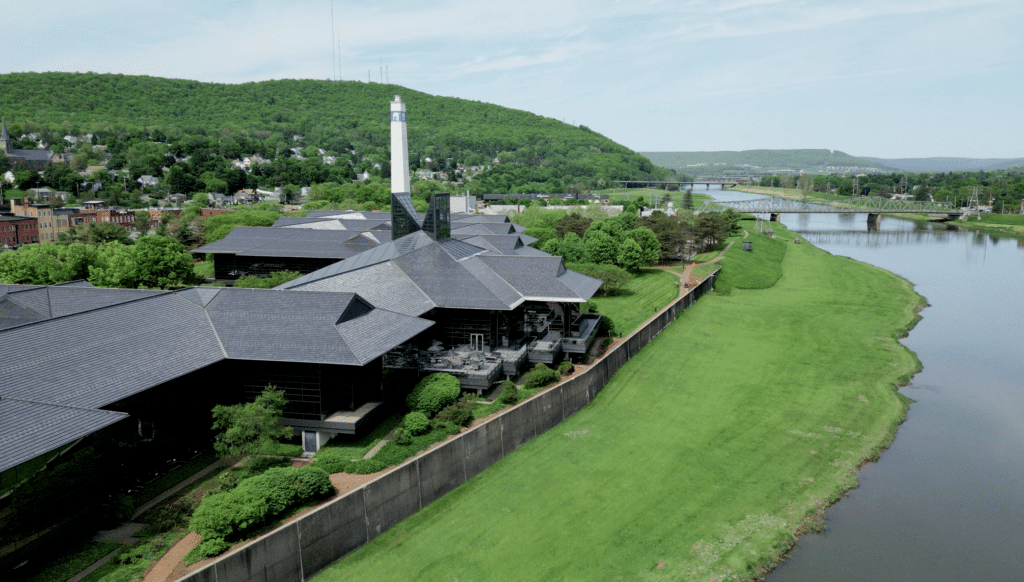 Black-shingled riverside building with a chimney along the water in the Southern Finger Lakes